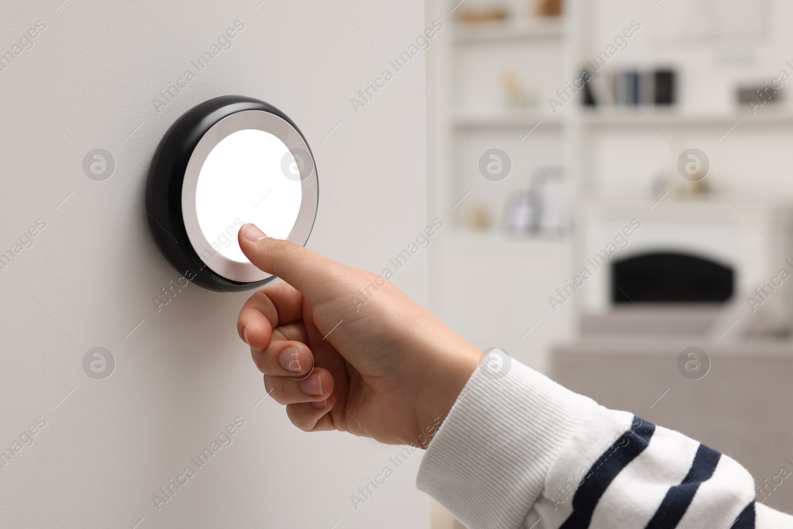 Photo of Woman adjusting thermostat on white wall indoors, closeup. Smart home system