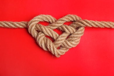 Photo of Heart made of rope on color background, top view