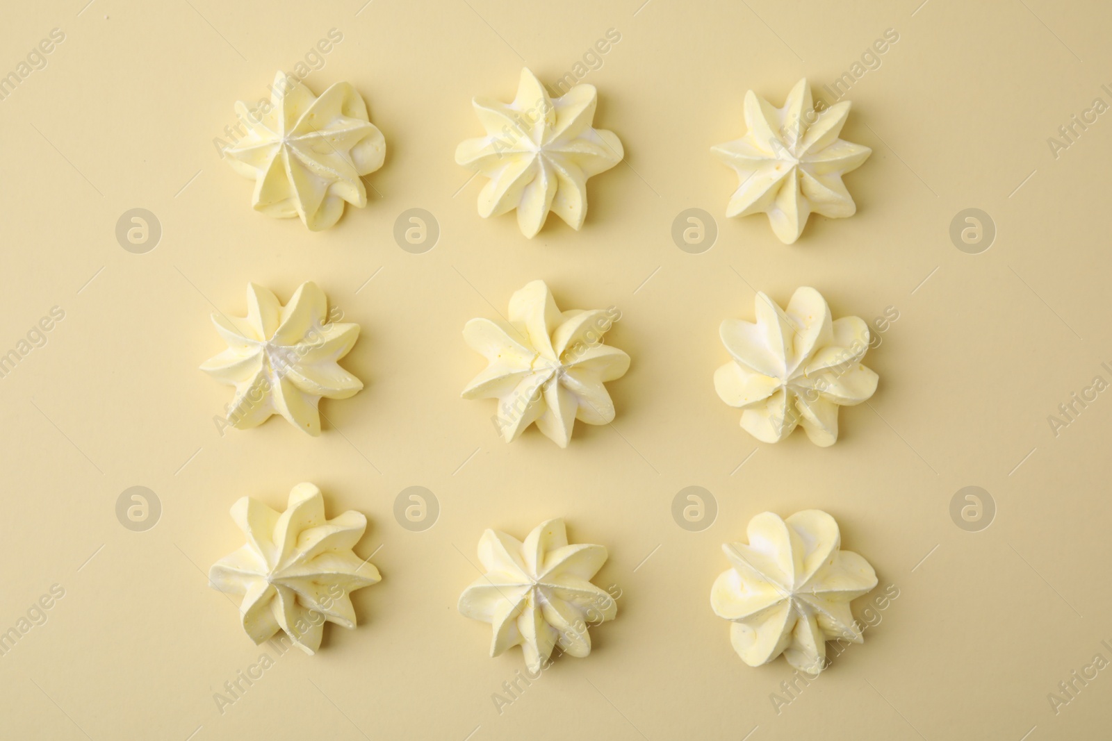 Photo of Delicious meringue cookies on beige background, flat lay