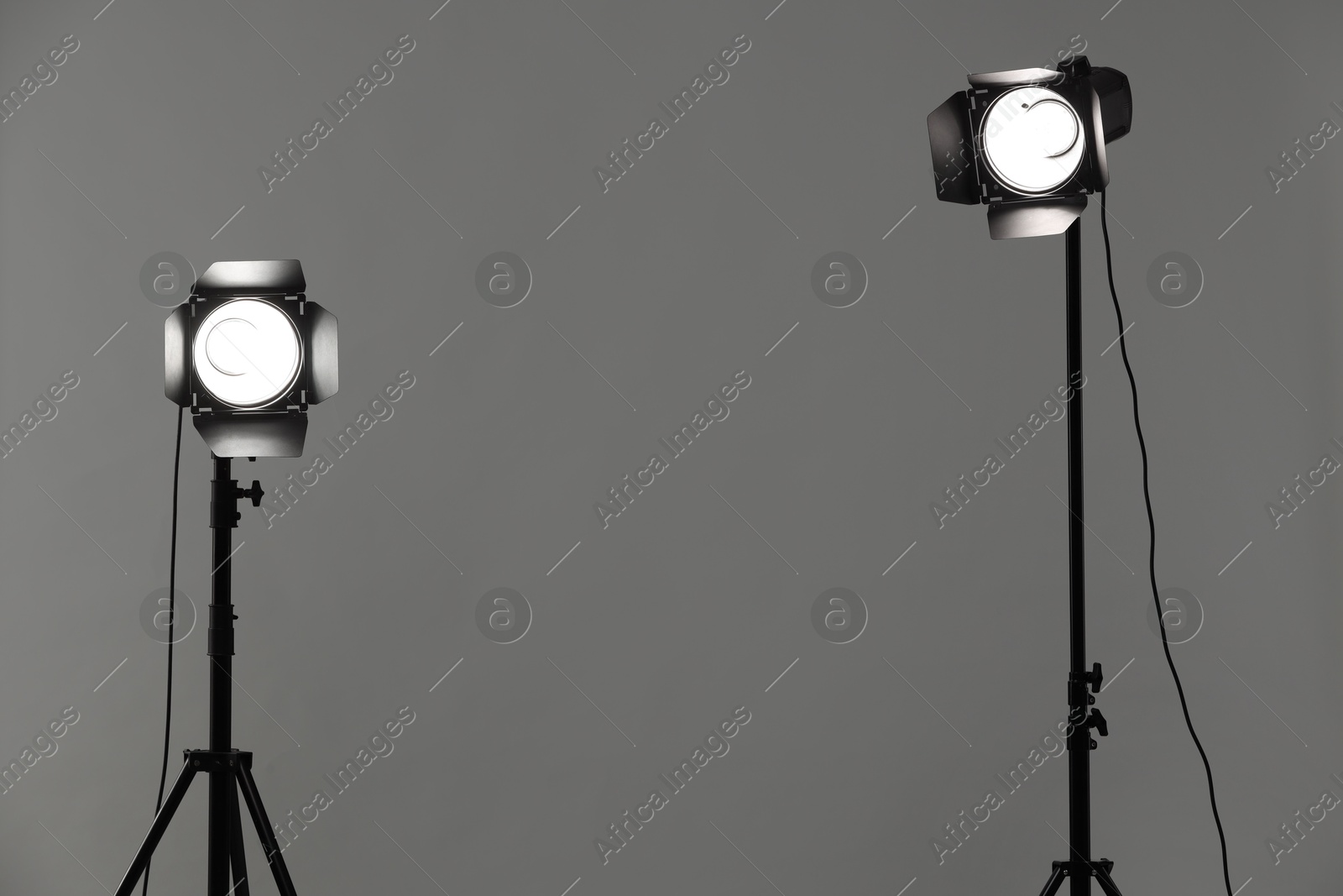 Photo of Grey photo background and professional lighting equipment in studio