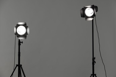 Grey photo background and professional lighting equipment in studio