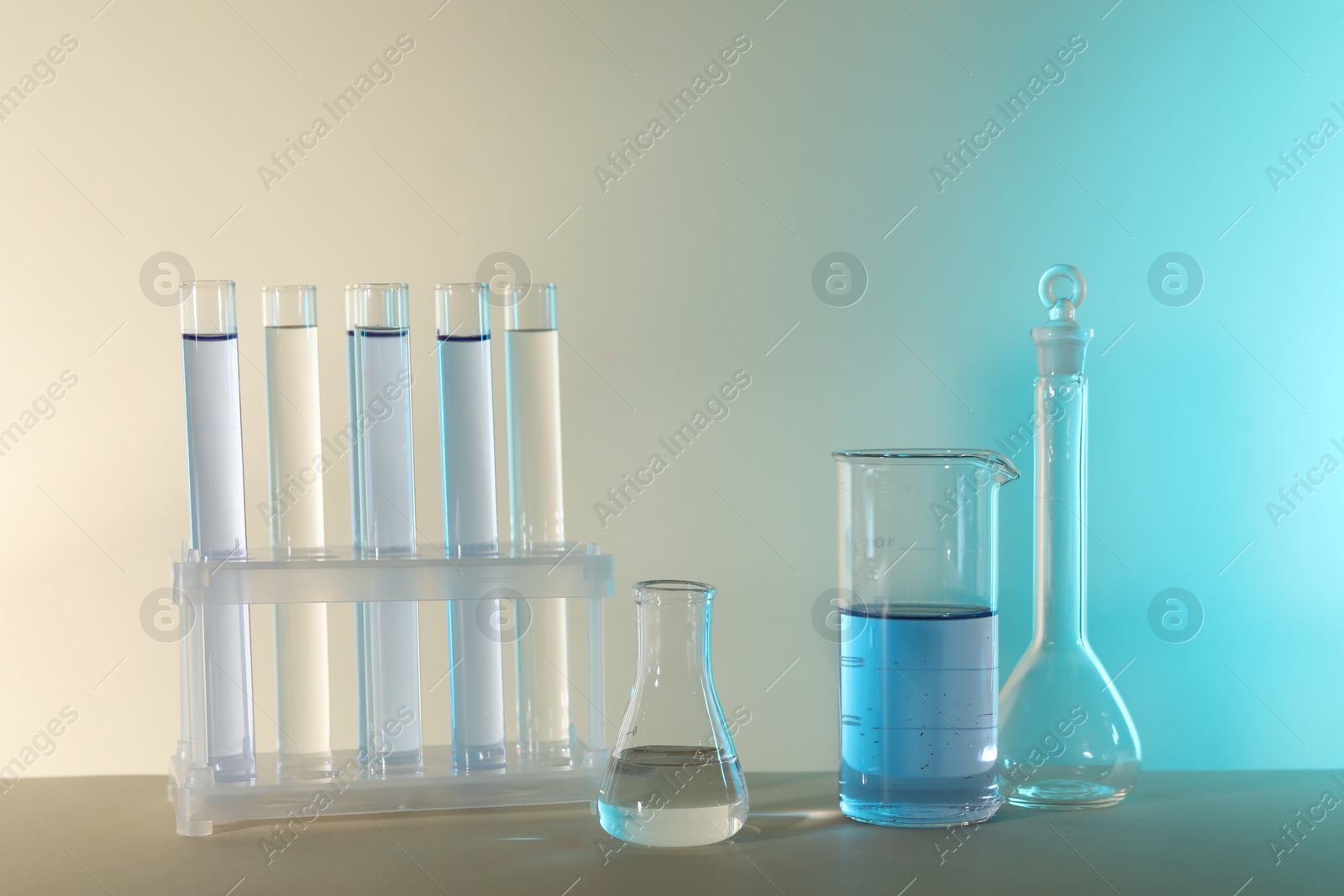 Photo of Laboratory analysis. Different glassware on table against color background