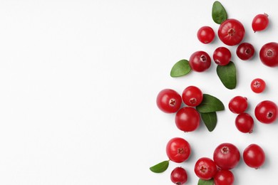 Photo of Fresh ripe cranberries and green leaves on white background, flat lay. Space for text