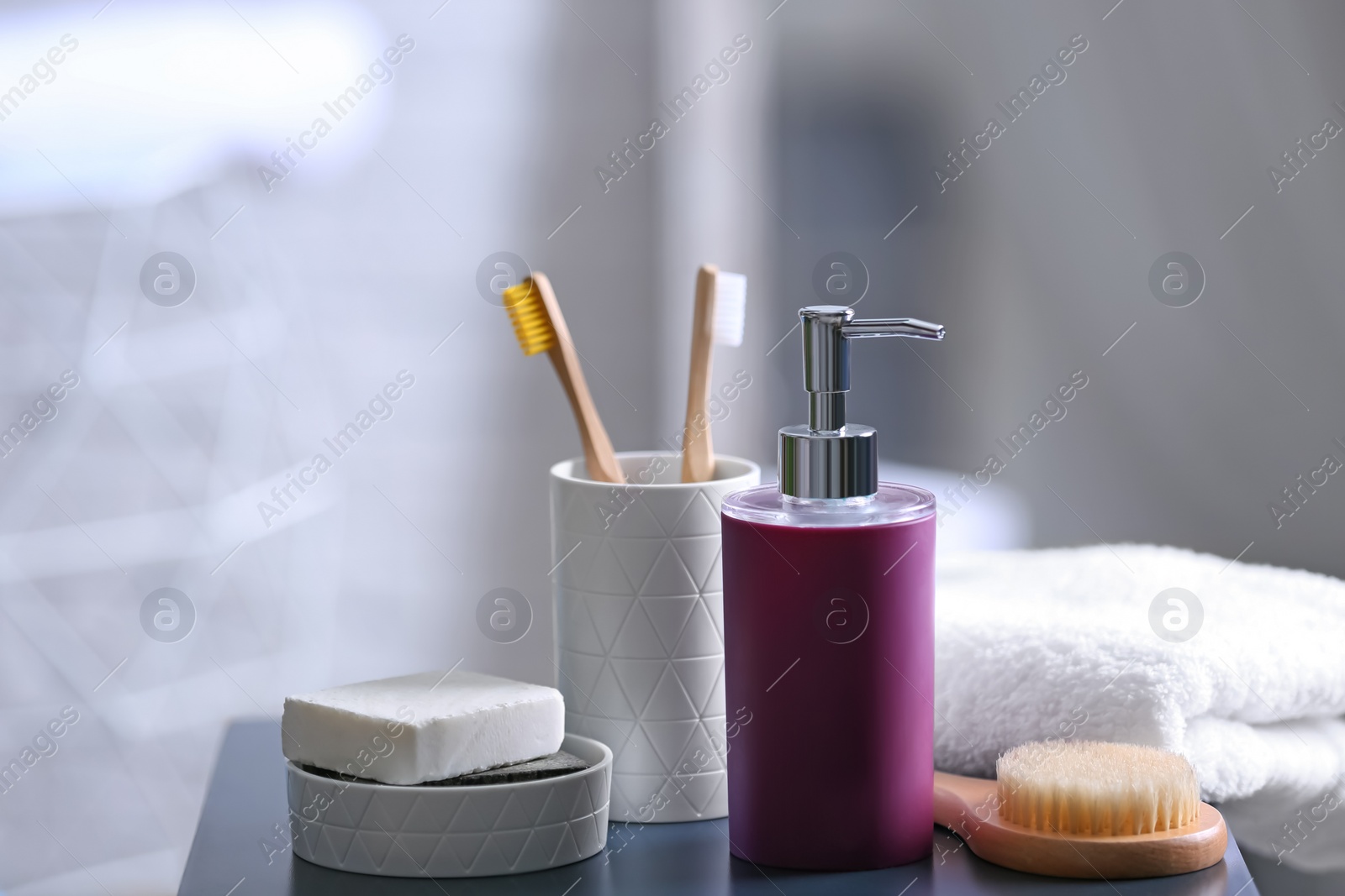 Photo of Aromatic soap and toiletries on table against blurred background. Space for text