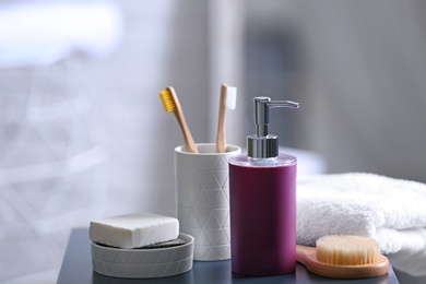 Photo of Aromatic soap and toiletries on table against blurred background. Space for text