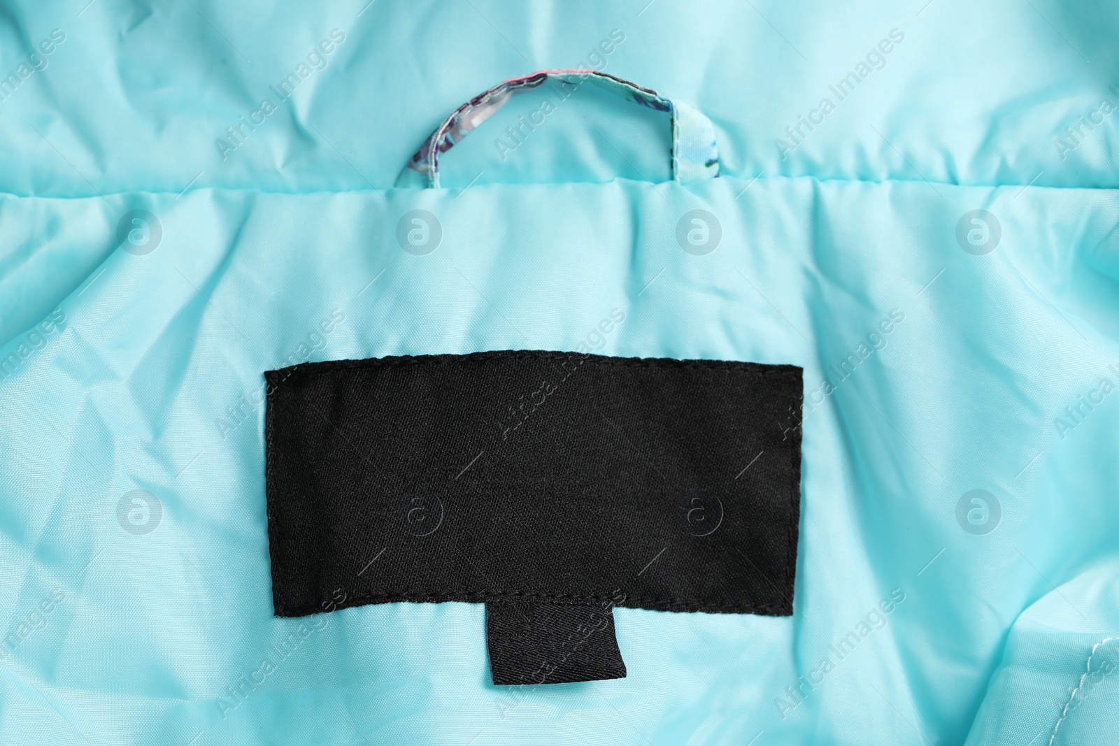 Photo of Clothing label on turquoise garment, top view