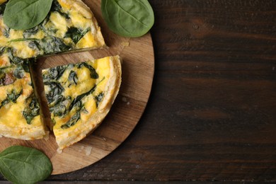 Photo of Delicious pie with spinach on wooden table, top view. Space for text