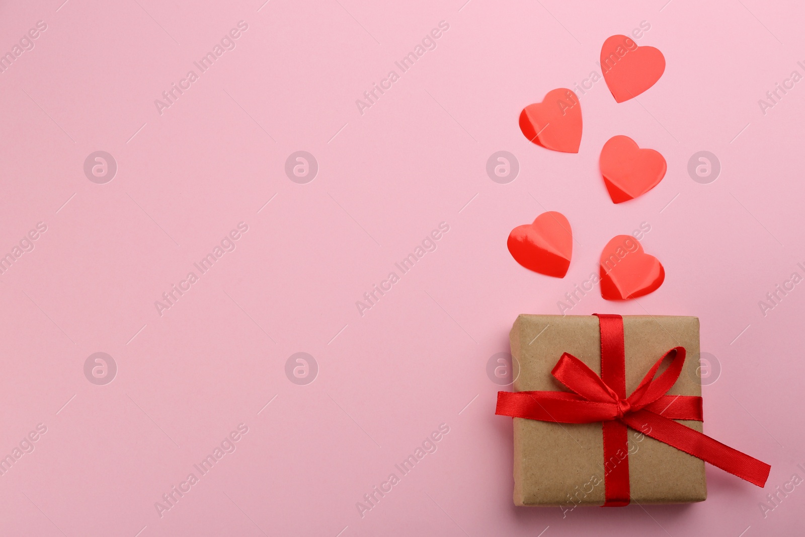 Photo of Beautiful gift box and hearts on pink background, flat lay with space for text. Valentine's day celebration