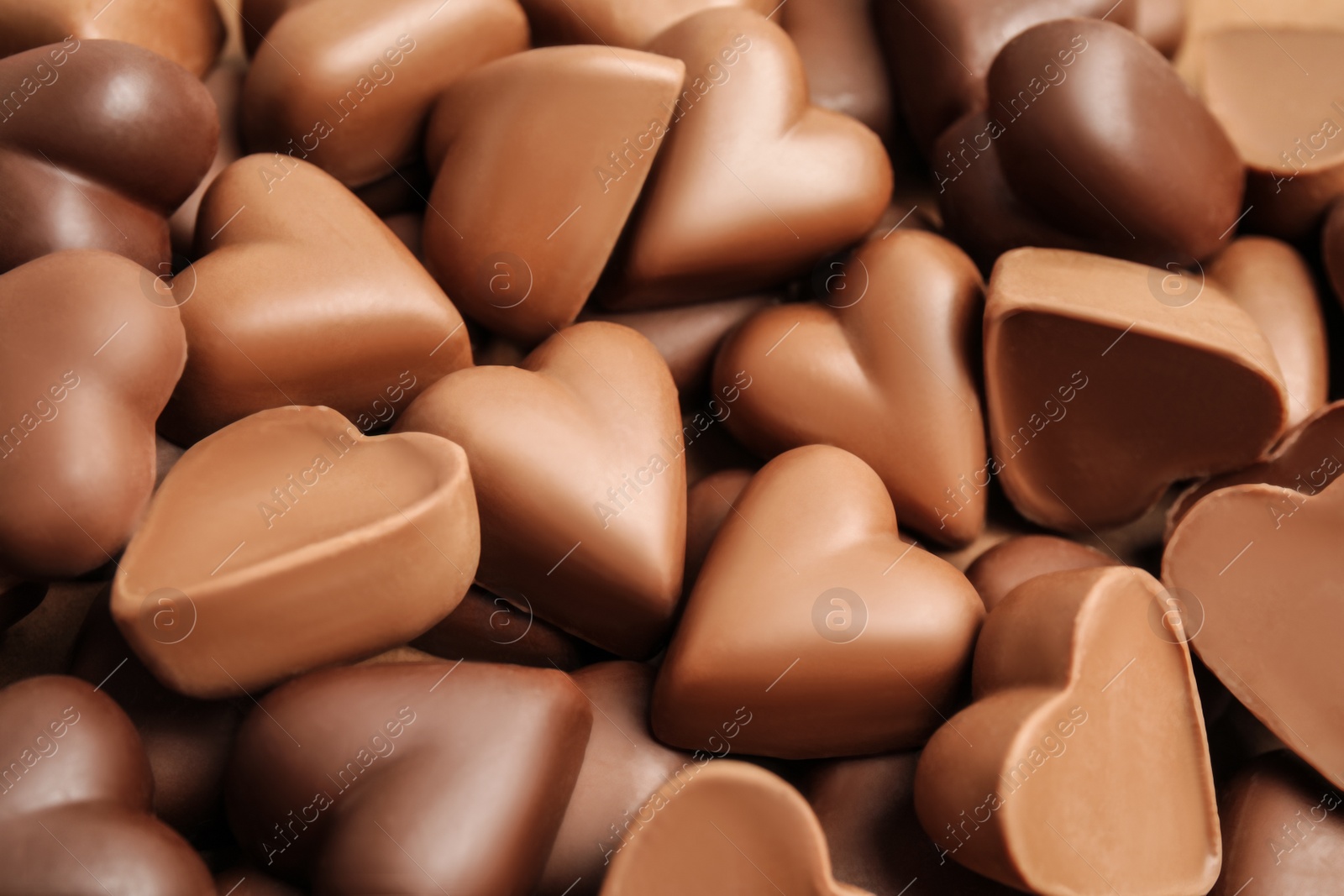 Photo of Tasty heart shaped chocolate candies as background, closeup. Valentine's day celebration