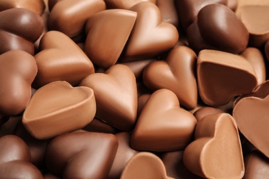 Photo of Tasty heart shaped chocolate candies as background, closeup. Valentine's day celebration