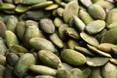 Photo of Shelled raw pumpkin seeds as background, closeup