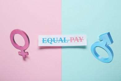 Photo of Equal pay concept. Gender symbols on color background, flat lay
