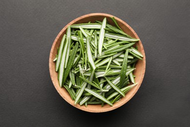 Photo of Wooden bowl of fresh green rosemary leaves on grey background, top view