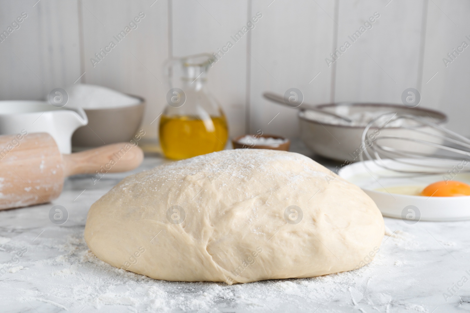 Photo of Fresh yeast dough and ingredients on white marble table