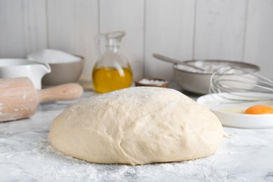 Photo of Fresh yeast dough and ingredients on white marble table