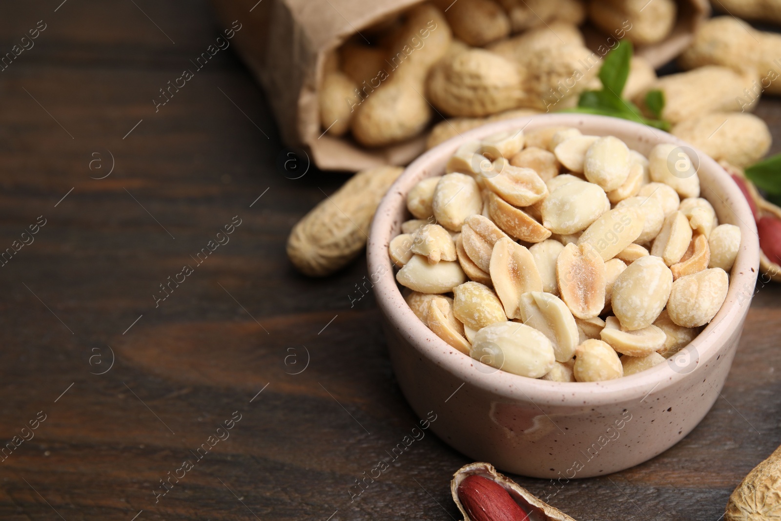 Photo of Fresh peanuts on wooden table, closeup. Space for text