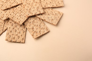 Photo of Fresh crunchy crispbreads on beige background, above view. Space for text