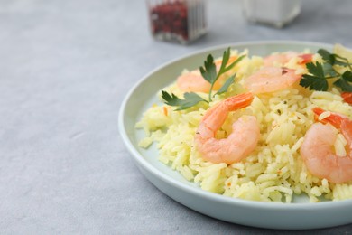 Photo of Delicious risotto with shrimps and parsley on light grey table, closeup. Space for text