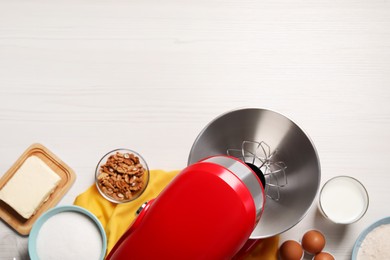 Modern red stand mixer and different ingredients on white wooden table, flat lay. Space for text