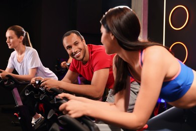 Photo of Group of people training on exercise bikes in fitness club