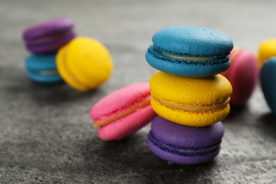 Photo of Delicious colorful macarons on grey table, closeup