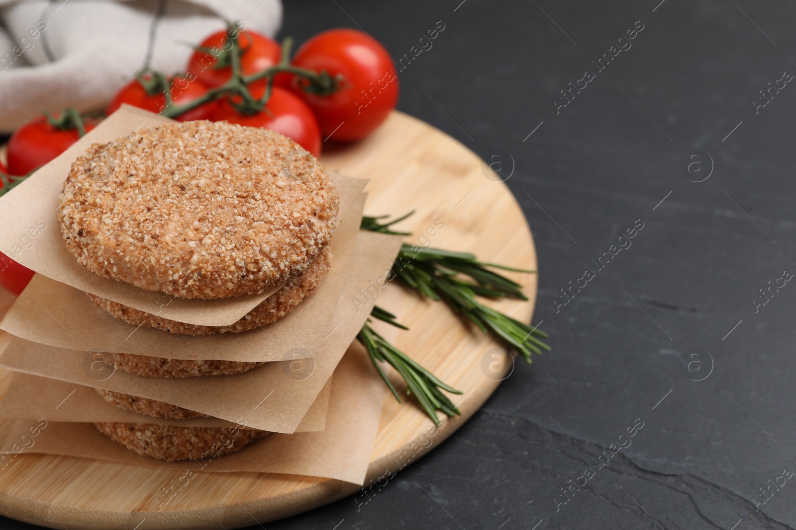 Photo of Raw vegan cutlets with breadcrumbs on black table, space for text