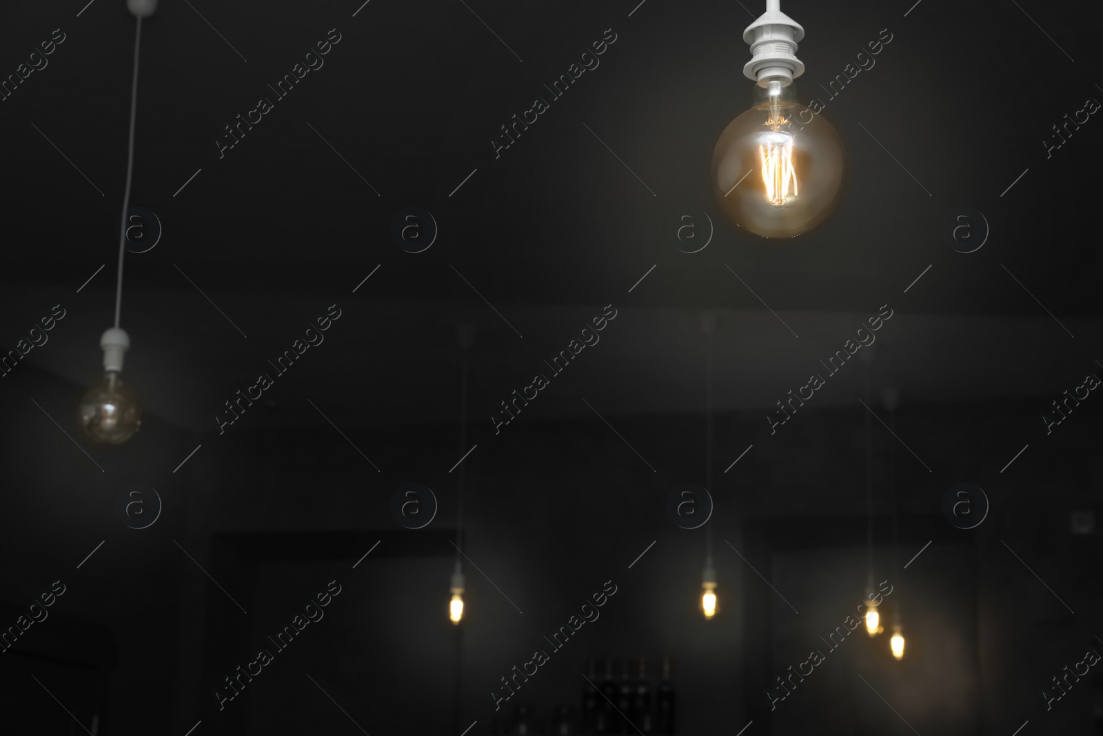 Photo of Lamp bulbs in dark room. Space for text