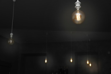 Photo of Lamp bulbs in dark room. Space for text