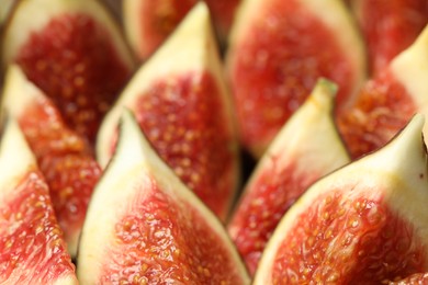 Photo of Slices of tasty fresh figs as background, closeup