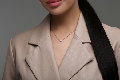 Photo of Young woman with elegant necklace on dark grey background, closeup
