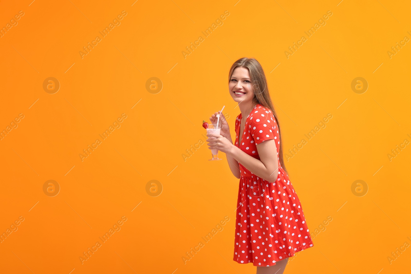 Photo of Young woman with glass of delicious milk shake on color background