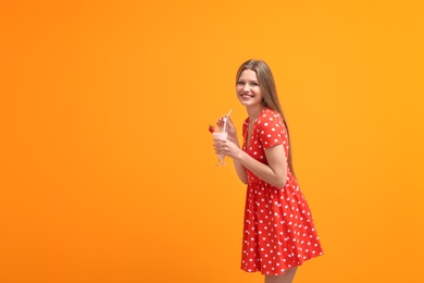 Photo of Young woman with glass of delicious milk shake on color background