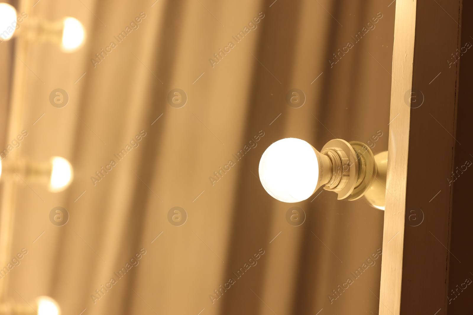 Photo of Modern mirror with light bulbs in makeup room, closeup