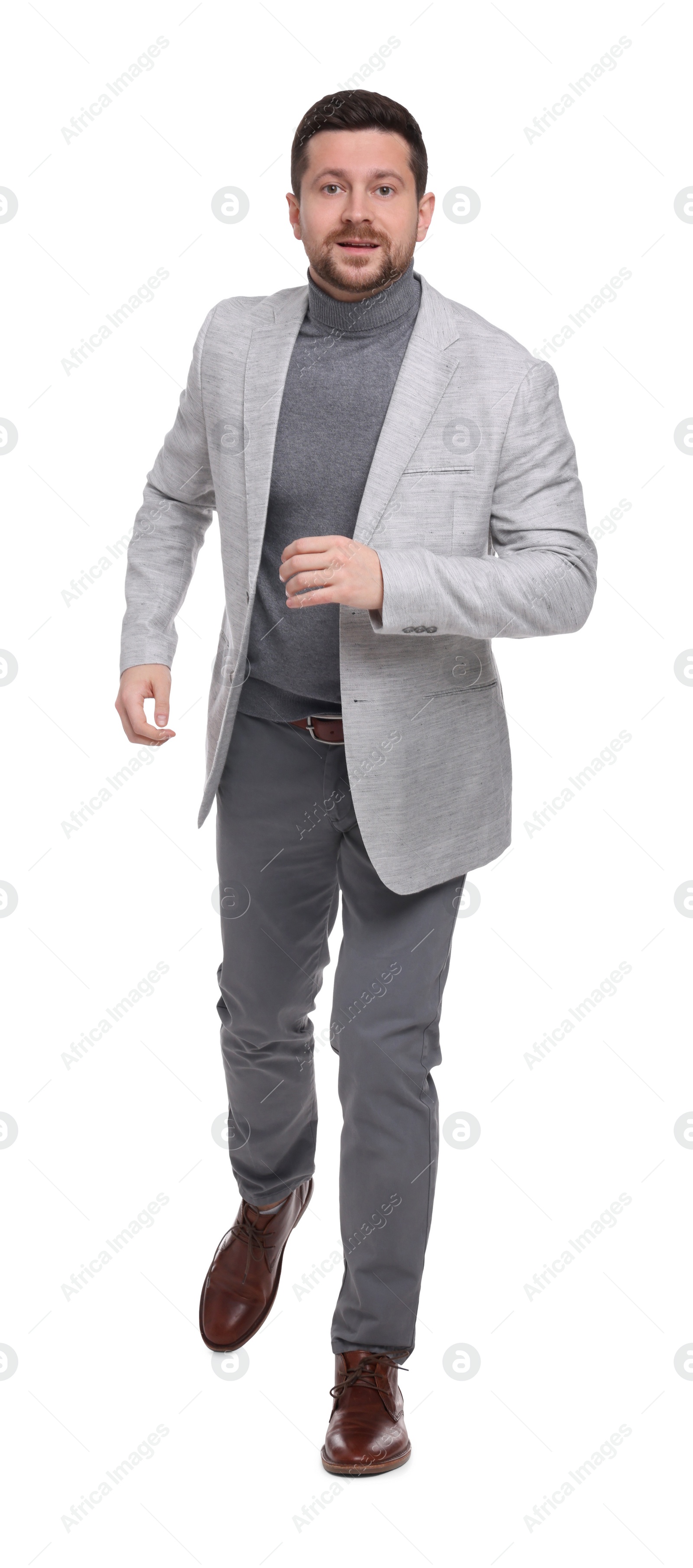 Photo of Handsome bearded businessman walking on white background