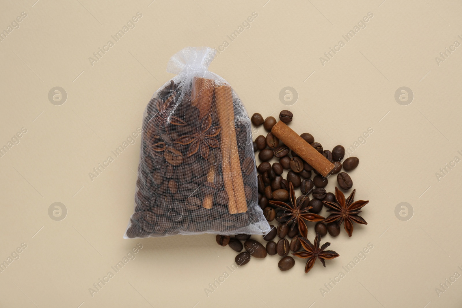 Photo of Scented sachet with coffee beans, anise and cinnamon on beige background, flat lay