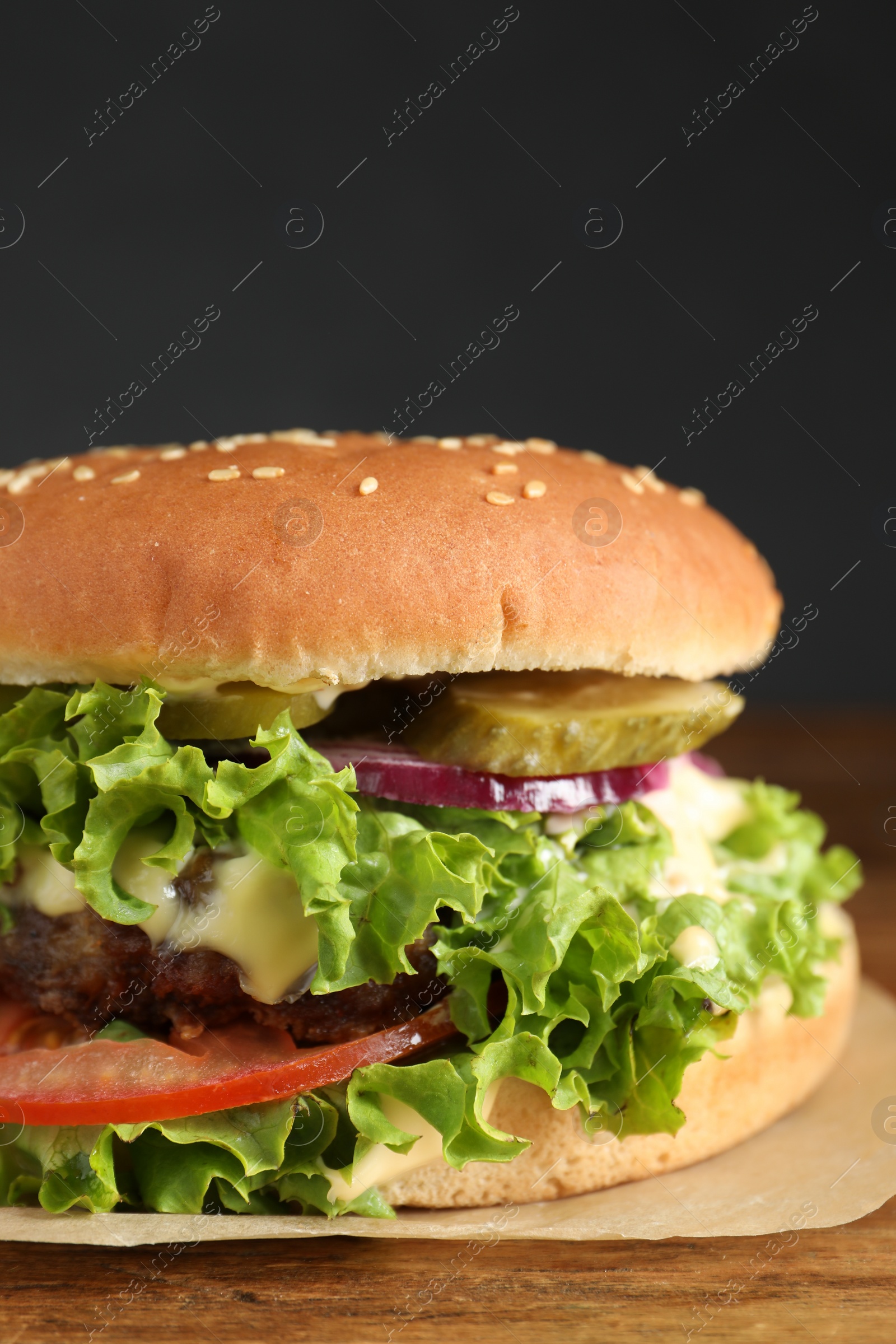 Photo of Delicious burger with beef patty and lettuce on table, closeup