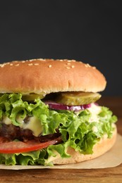 Photo of Delicious burger with beef patty and lettuce on table, closeup