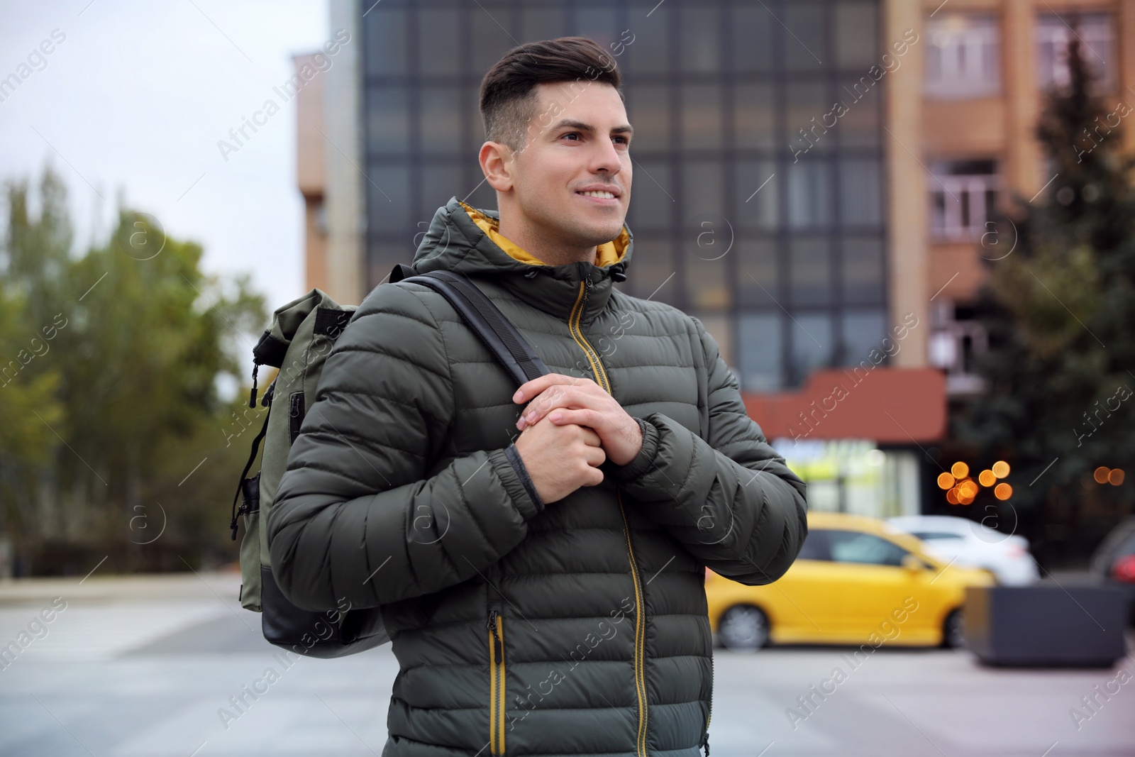 Photo of Male tourist with travel backpack on city street. Urban trip