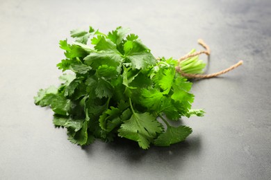 Photo of Bunch of fresh coriander on gray table