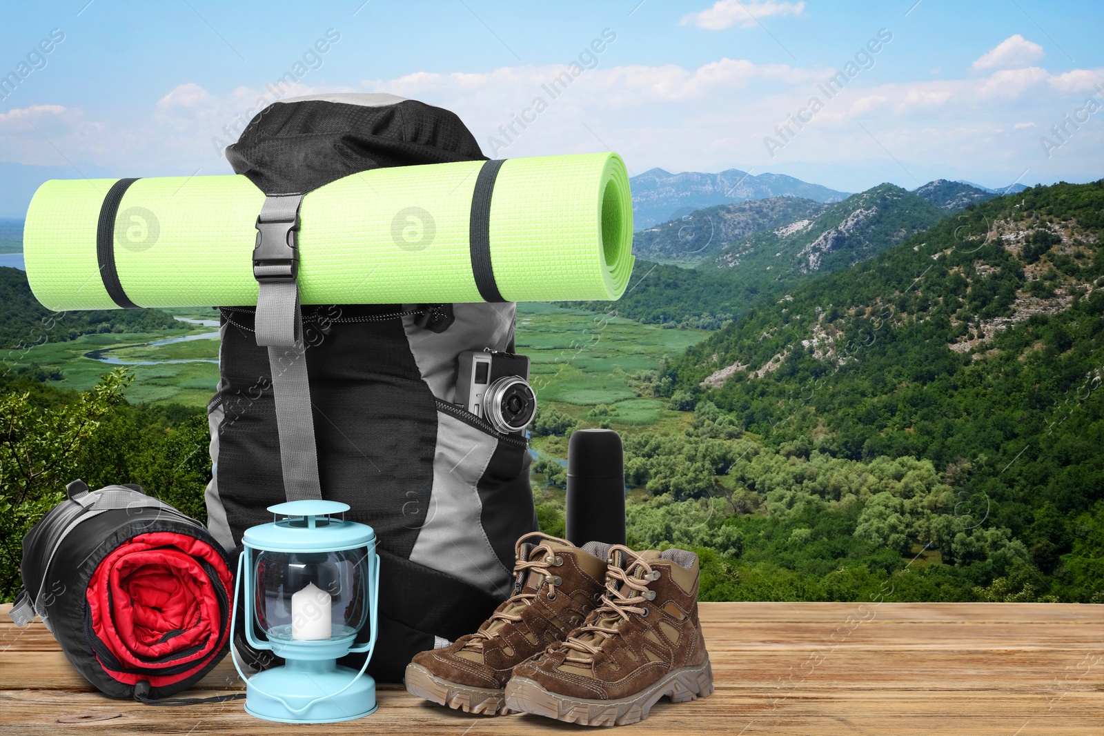 Image of Camping equipment for tourist on wooden surface and beautiful view of mountain landscape