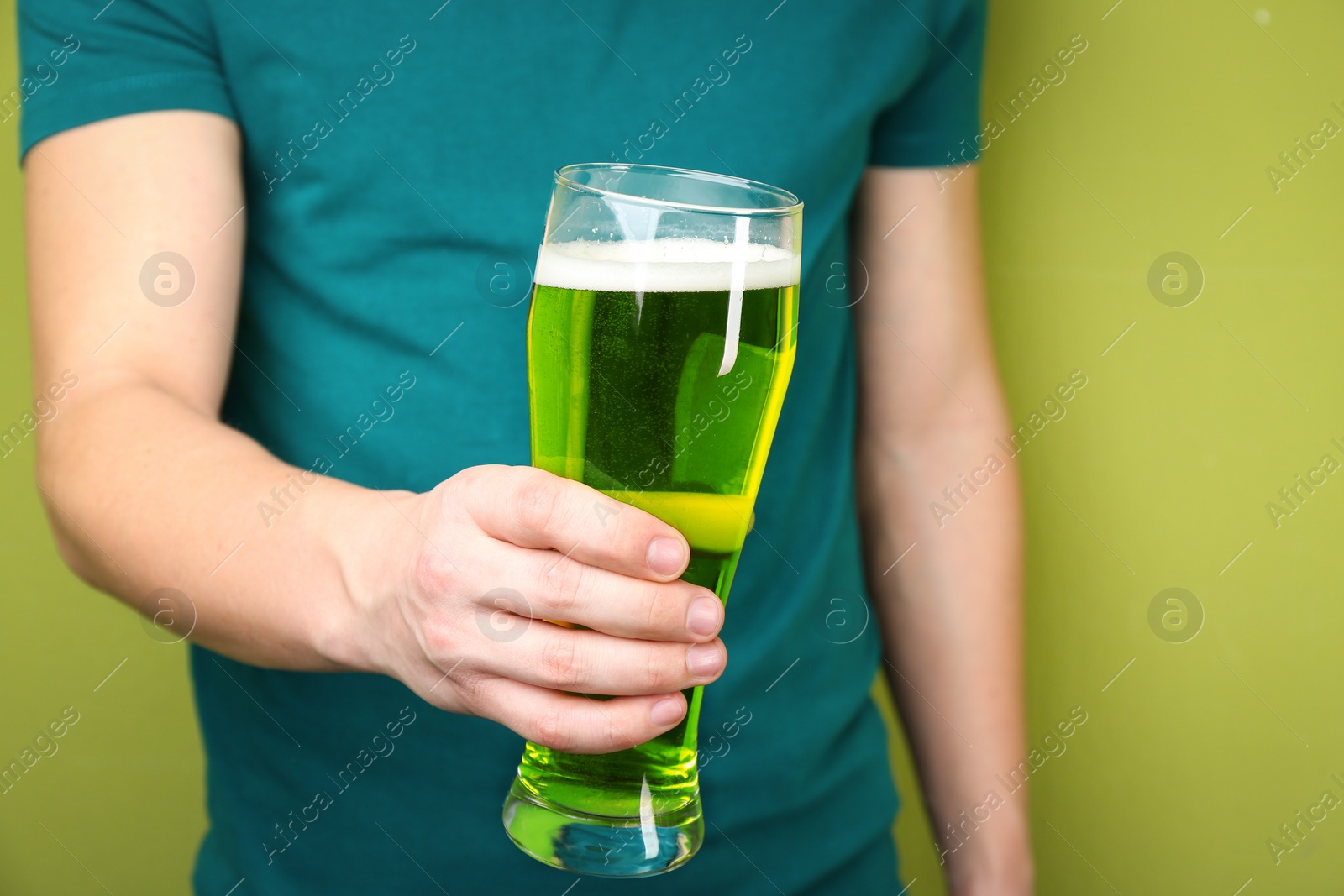 Photo of Man with green beer on color background, closeup. St. Patrick's Day celebration