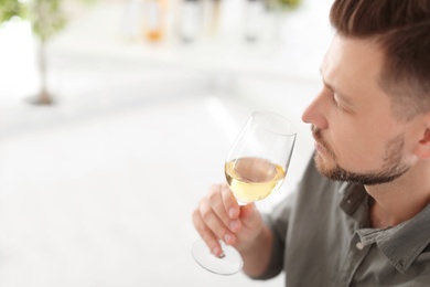 Photo of Man with glass of delicious wine indoors