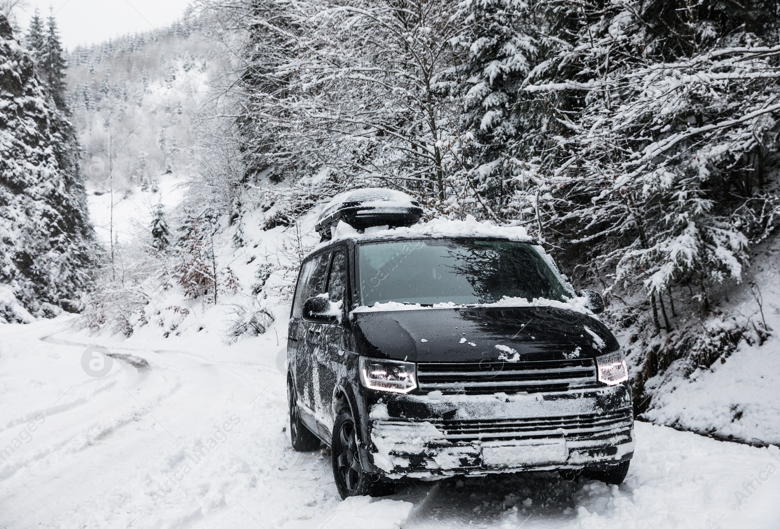 Photo of Modern car on snowy road near forest. Winter vacation