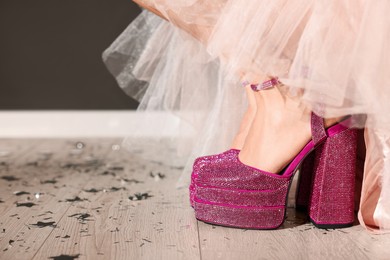 Photo of Stylish party. Woman wearing pink high heeled shoes with platform and square toes indoors, closeup. Space for text