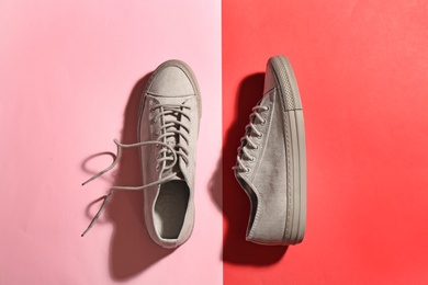 Pair of stylish sneakers on color background, flat lay