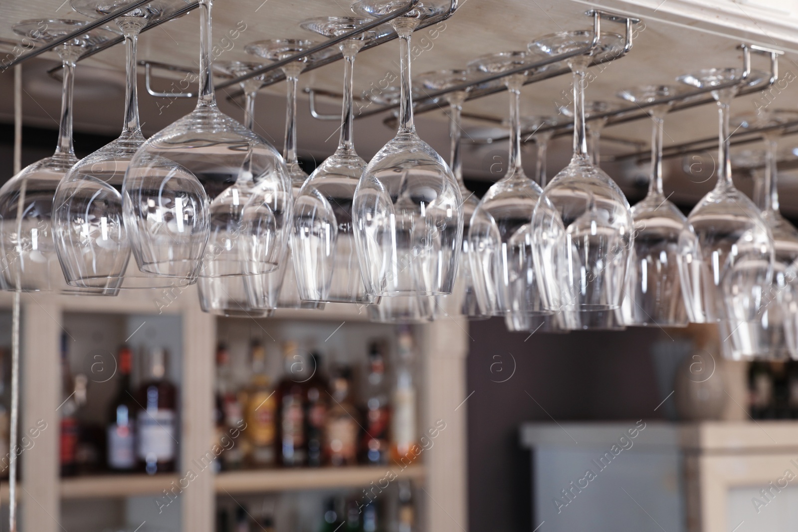 Photo of Set of empty clean glasses on bar racks