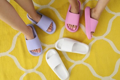 Photo of Women in pink and violet slippers indoors, closeup. Top view