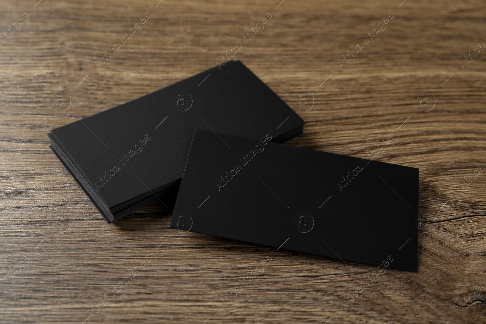 Photo of Blank black business cards on wooden background. Mockup for design