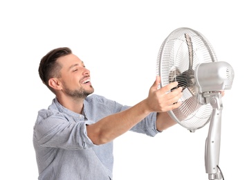 Man refreshing from heat in front of fan on white background