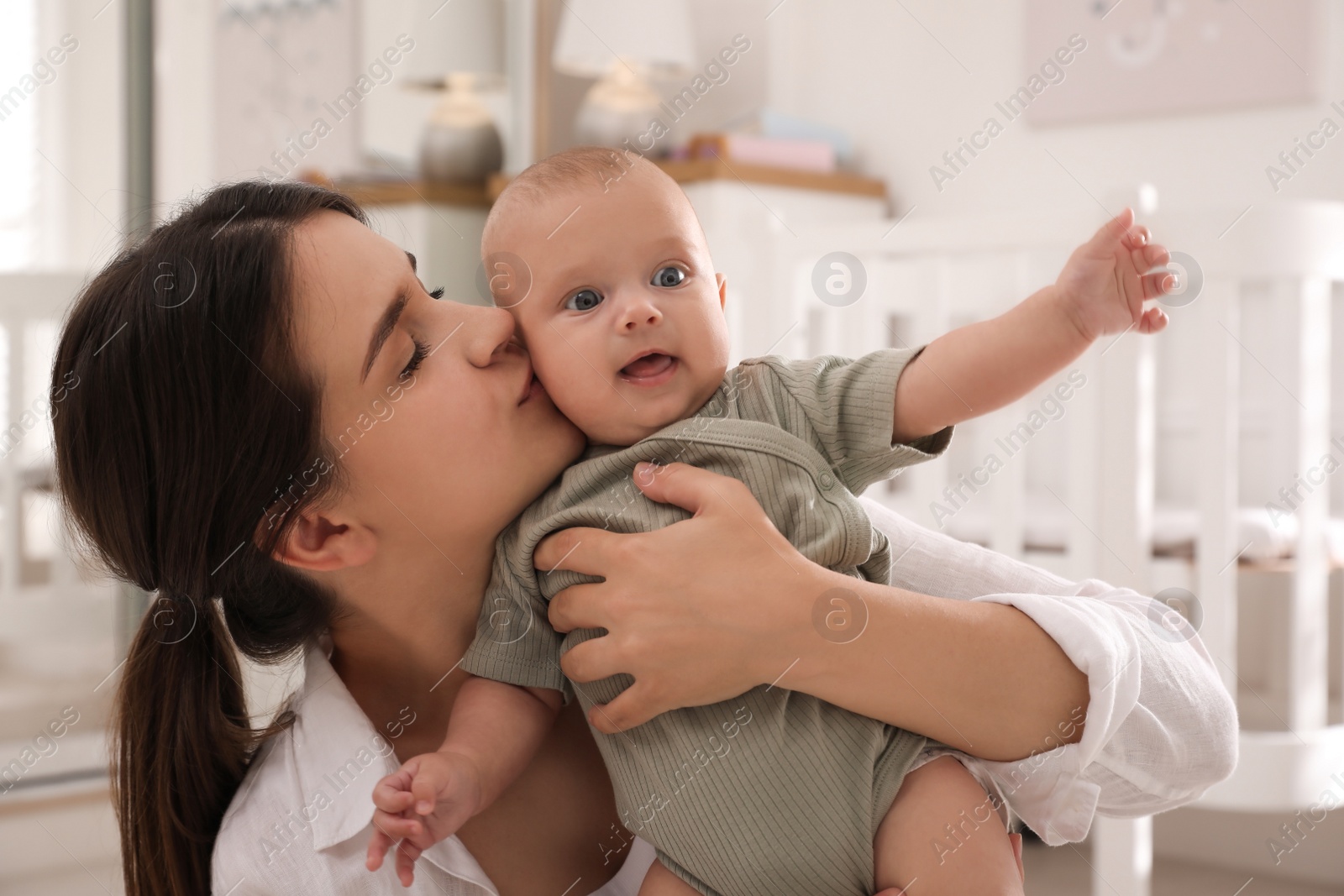 Photo of Happy young mother with her cute baby at home